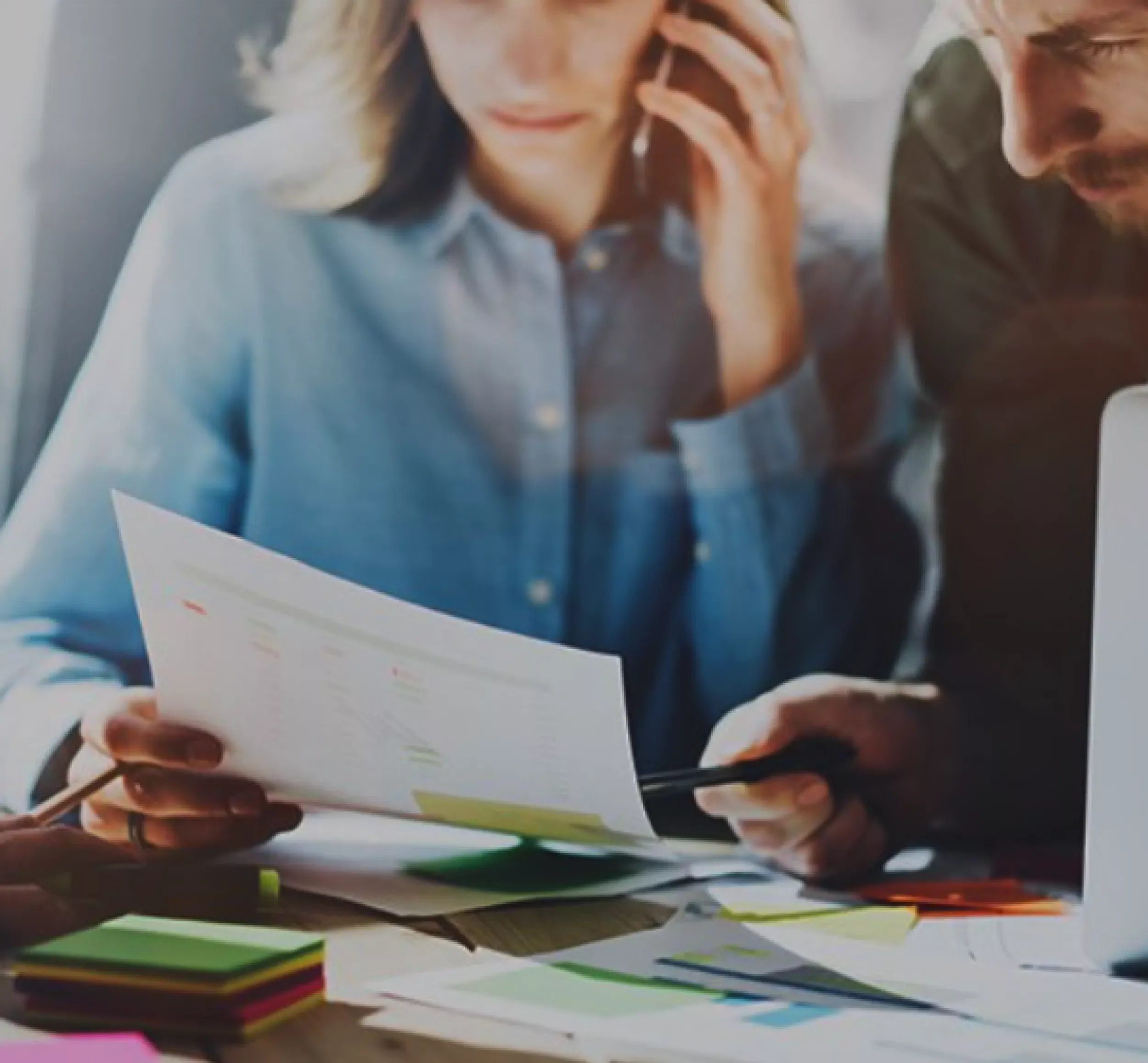 Kollegor som diskuterar rapporter och analyserar data i ett arbetsmöte.