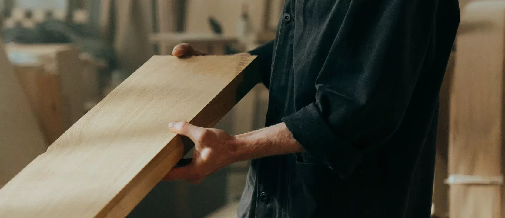 Person håller i en återanvänd träskiva i samband med miljöavveckling vid företagsflytt. Bilden symboliserar Joyweeks hållbara arbete med återbruk och miljövänlig hantering av material när företag flyttar till nya lokaler