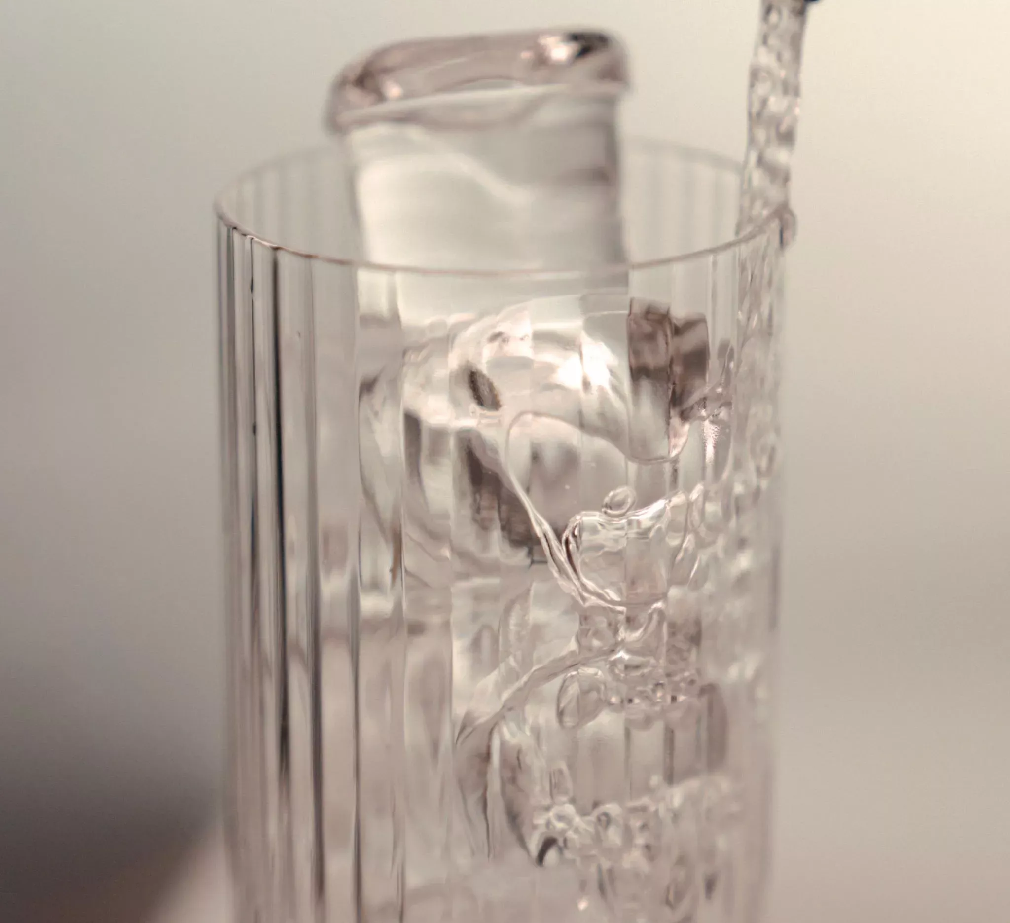 Kallt vatten hälls i glas, symbol för moderna vattenautomater på kontoret